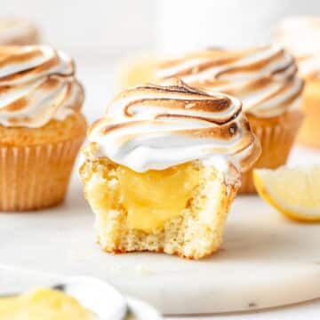 close up of lemon meringue cupcakes filled with lemon curd and topped with toasted meringue.