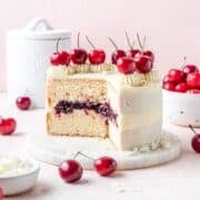 close up of white forest cake with whipped chocolate ganache and fresh cherries.