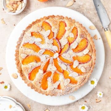 frangipane apricot tart with toasted almonds and powdered sugar.