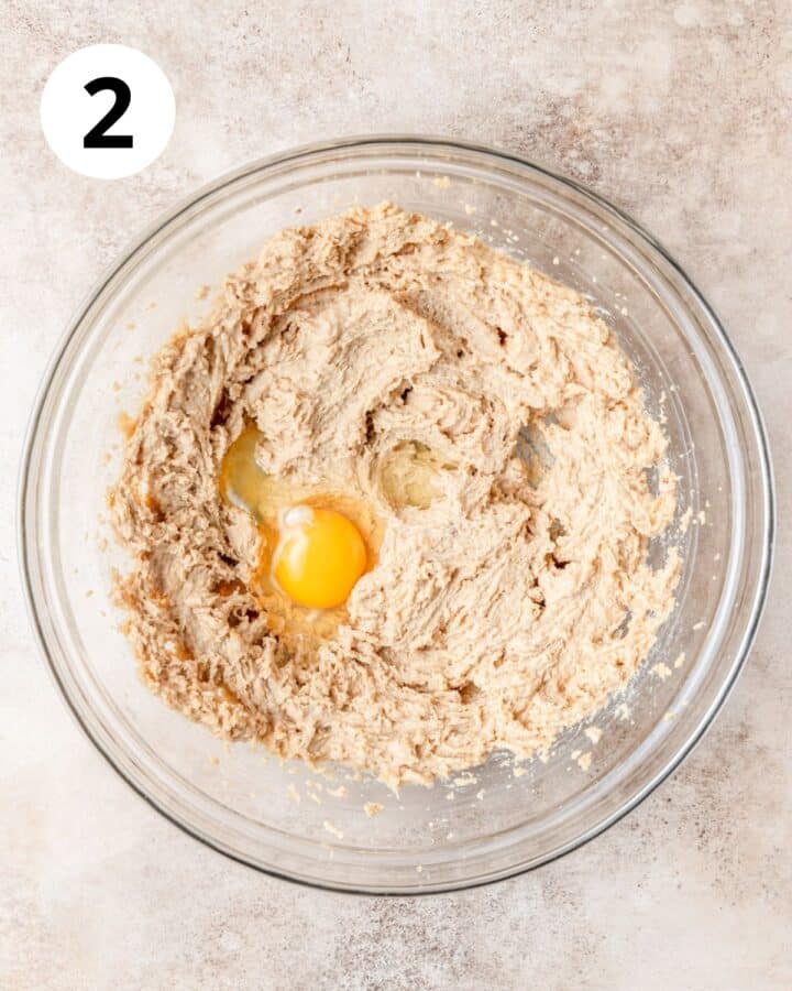 adding egg to cookie dough.