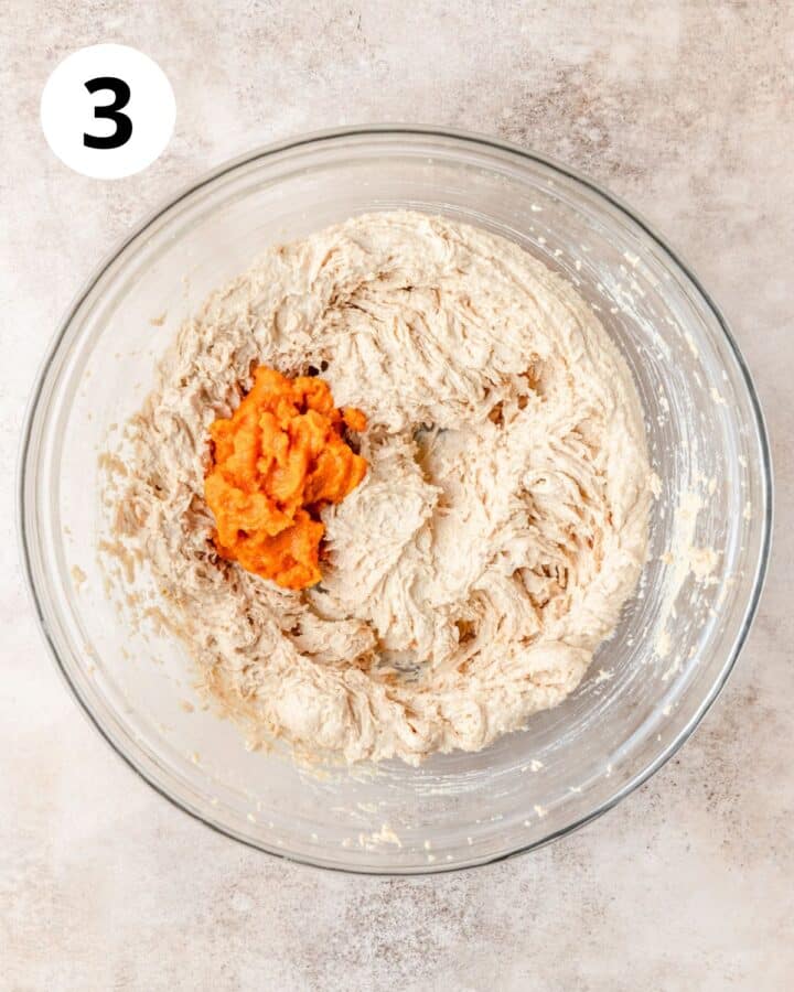adding pumpkin puree to cookie dough.