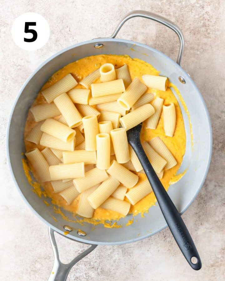 adding cooked pasta to pumpkin vodka sauce.