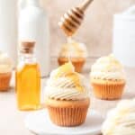 brown butter cornbread cupcakes being drizzled with honey.