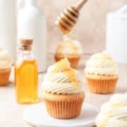 brown butter cornbread cupcakes being drizzled with honey.