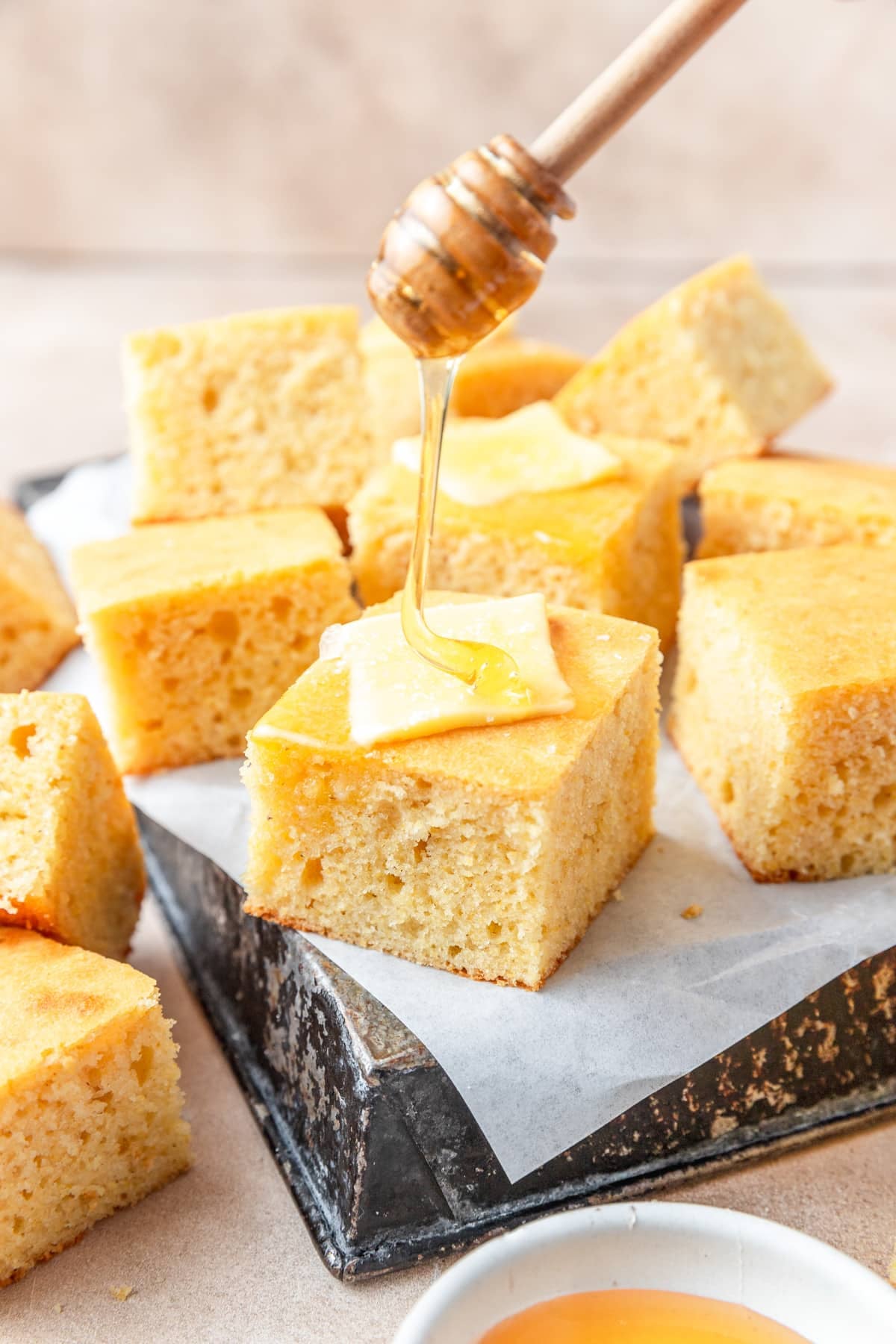 drizzling slice of sourdough cornbread with honey.