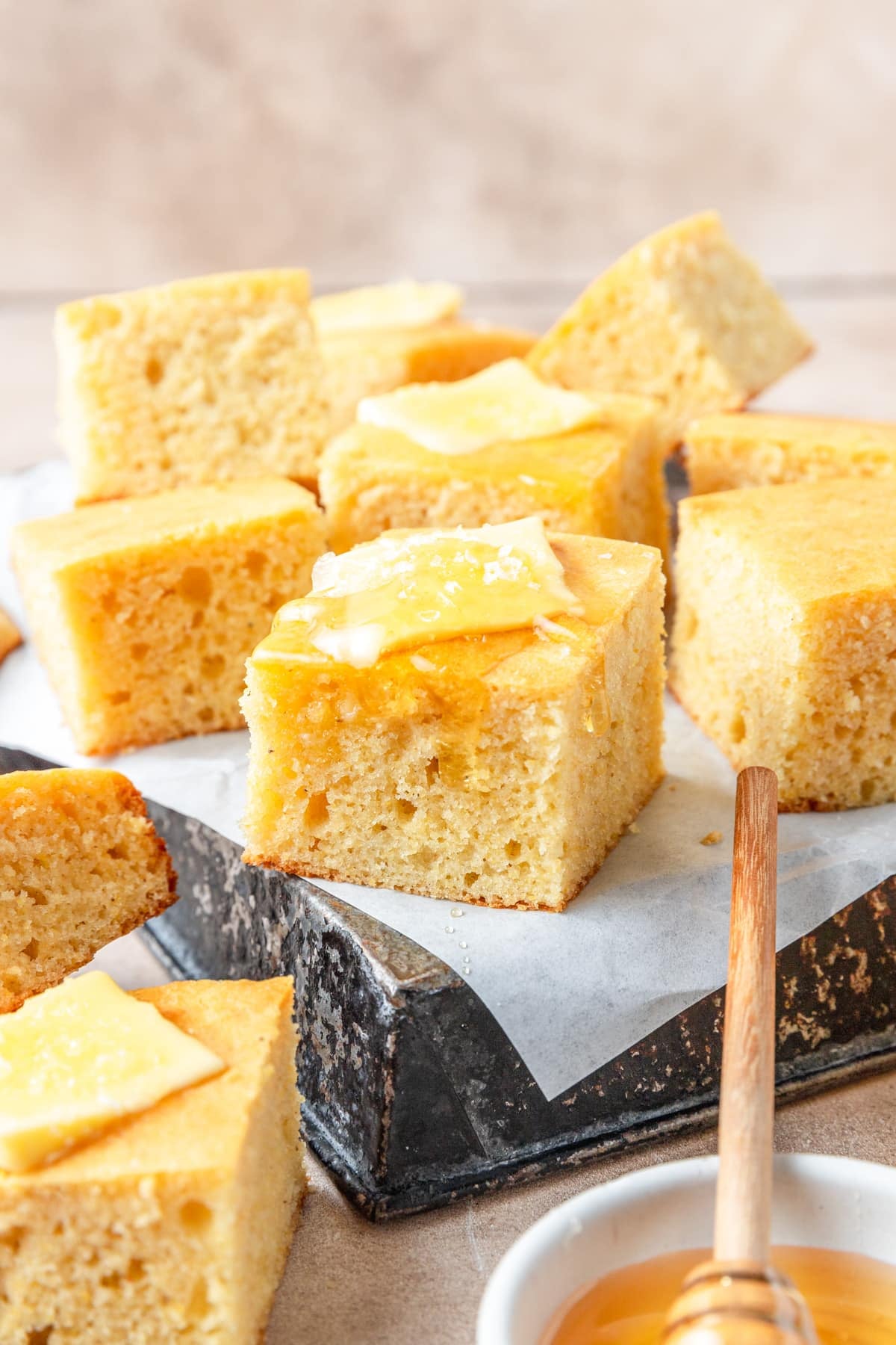 piece of sourdough cornbread topped with honey butter.