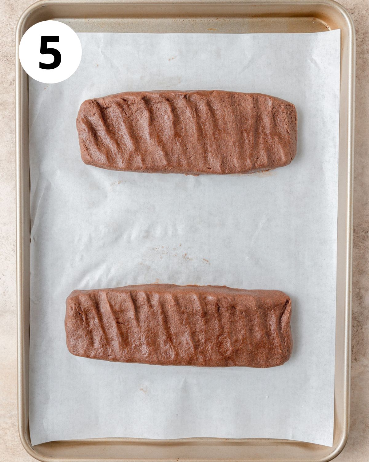 chocolate biscotti logs formed on baking sheet.