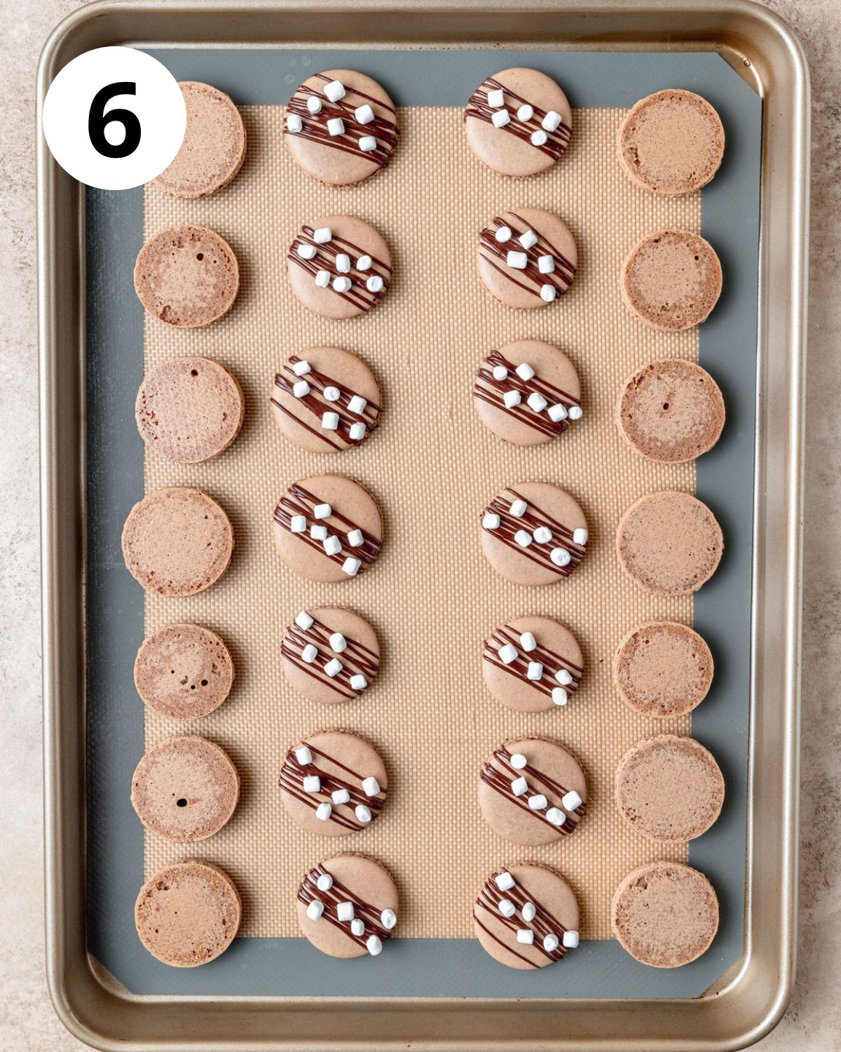 macaron tops decorated with chocolate drizzle and mini marshmallows.