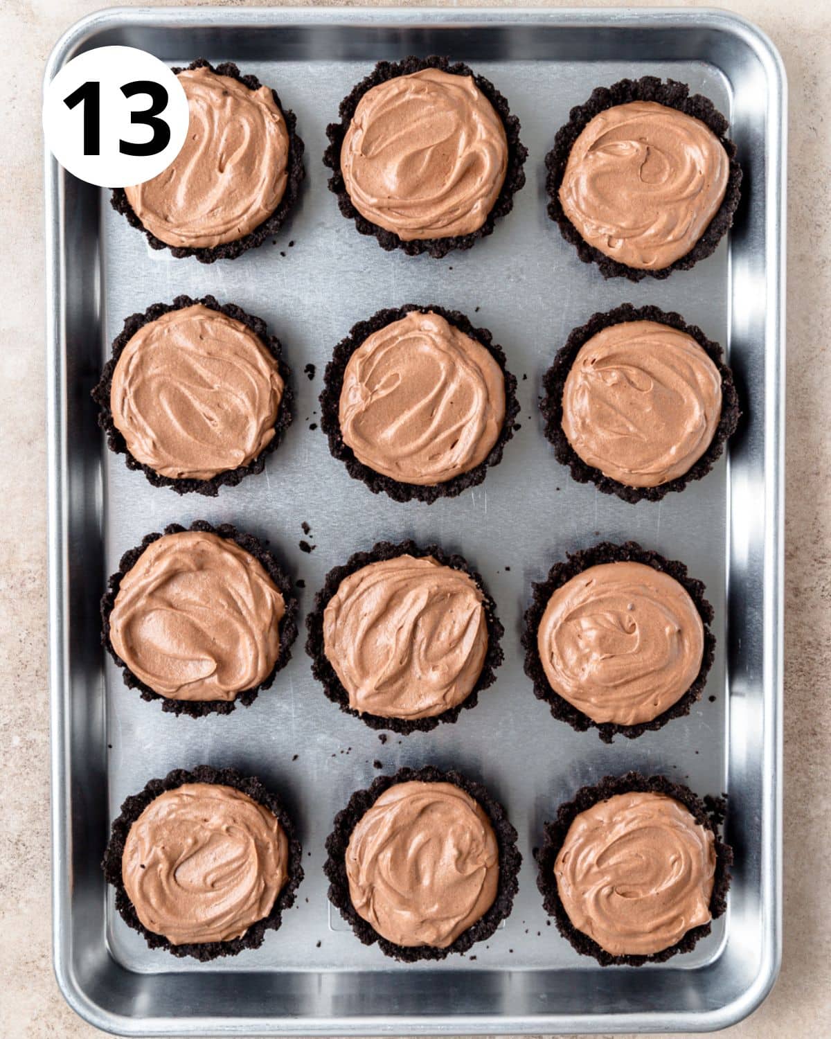 adding chocolate mousse to mini oreo shells.