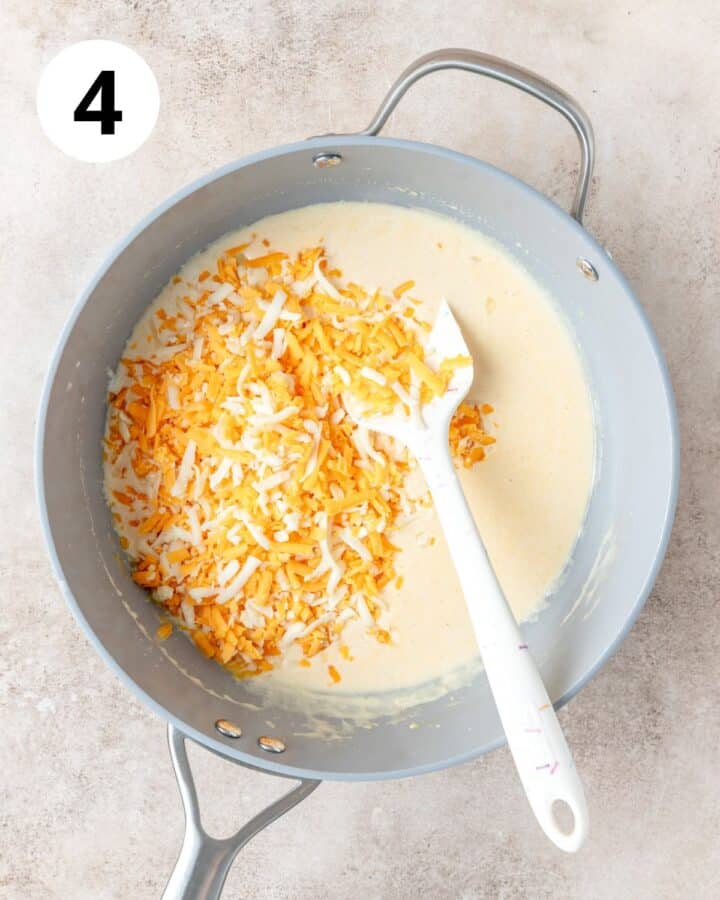 adding shredded cheese to sauce.