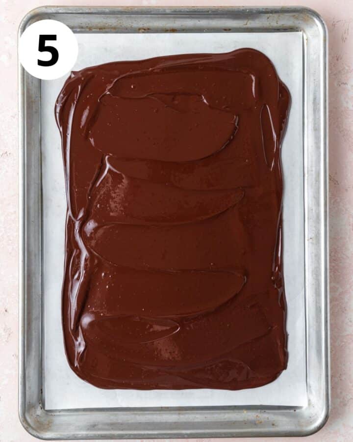 melted dark chocolate spread in even layer on parchment lined baking sheet.