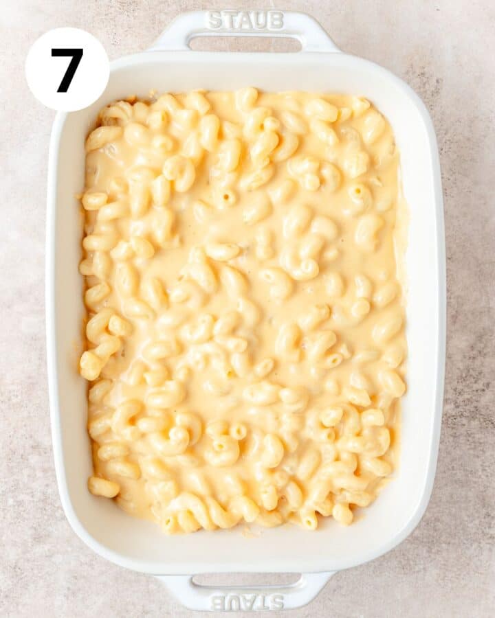 adding creamy Mac and cheese to casserole dish.