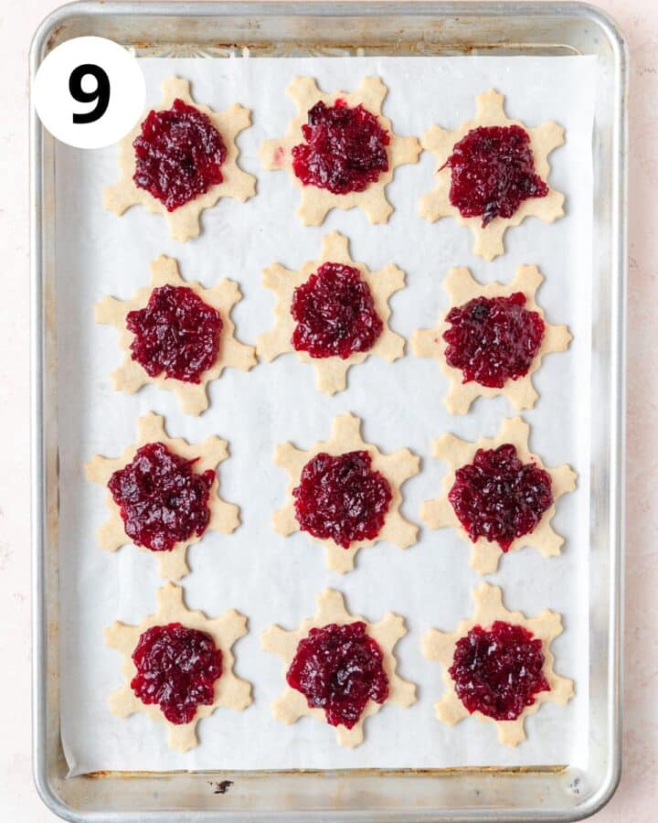 filling the linzer cookies with jam.