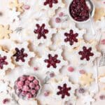 close up of snowflake shaped cranberry Linzer cookies.