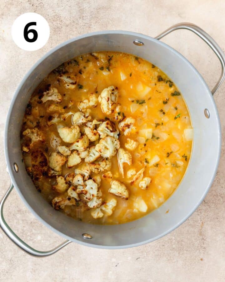 adding roasted garlic and cauliflower to soup.