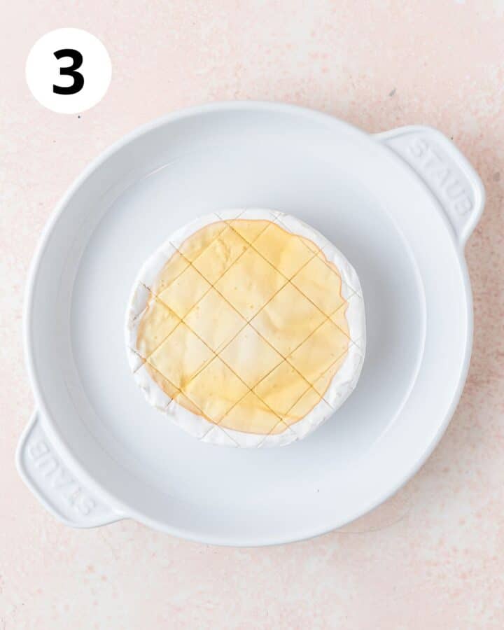 spreading honey on top of brie.