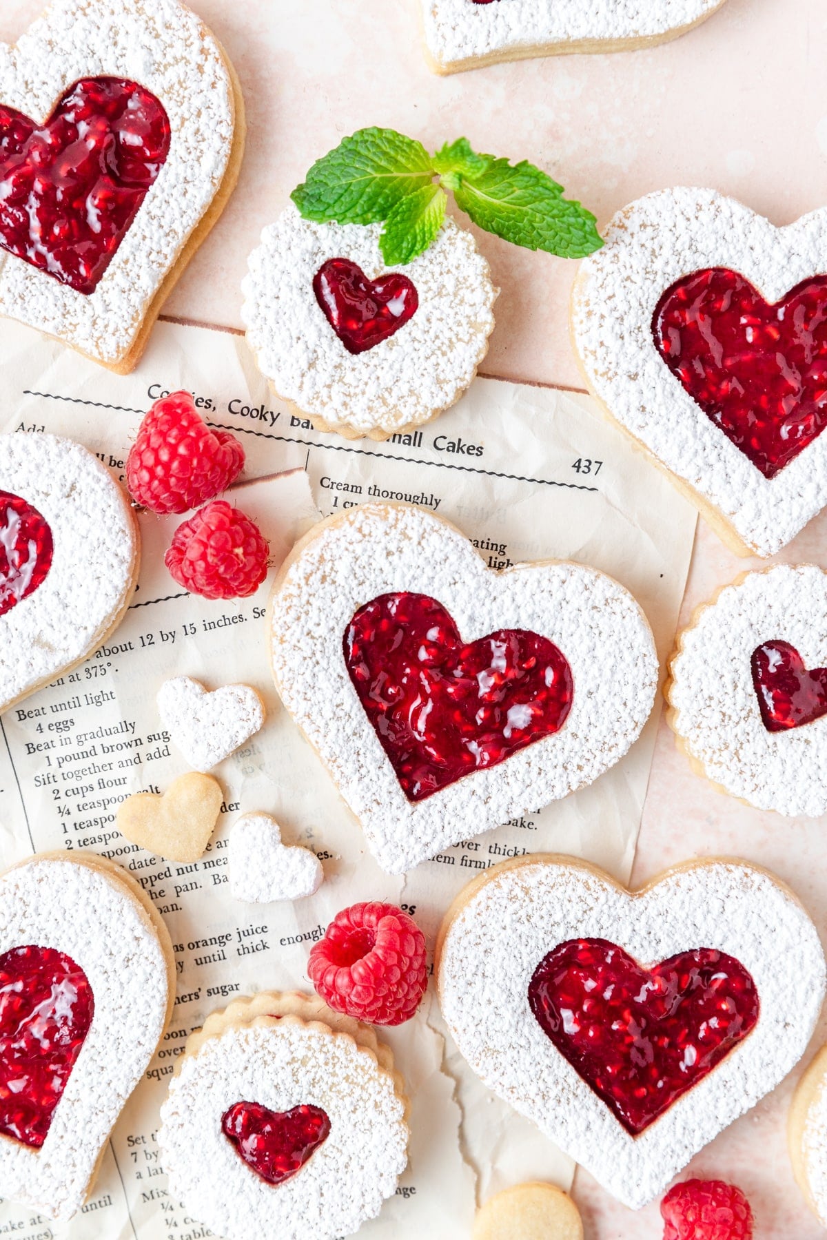 heart shaped raspberry linzer cookies dusted with powdered sugar.