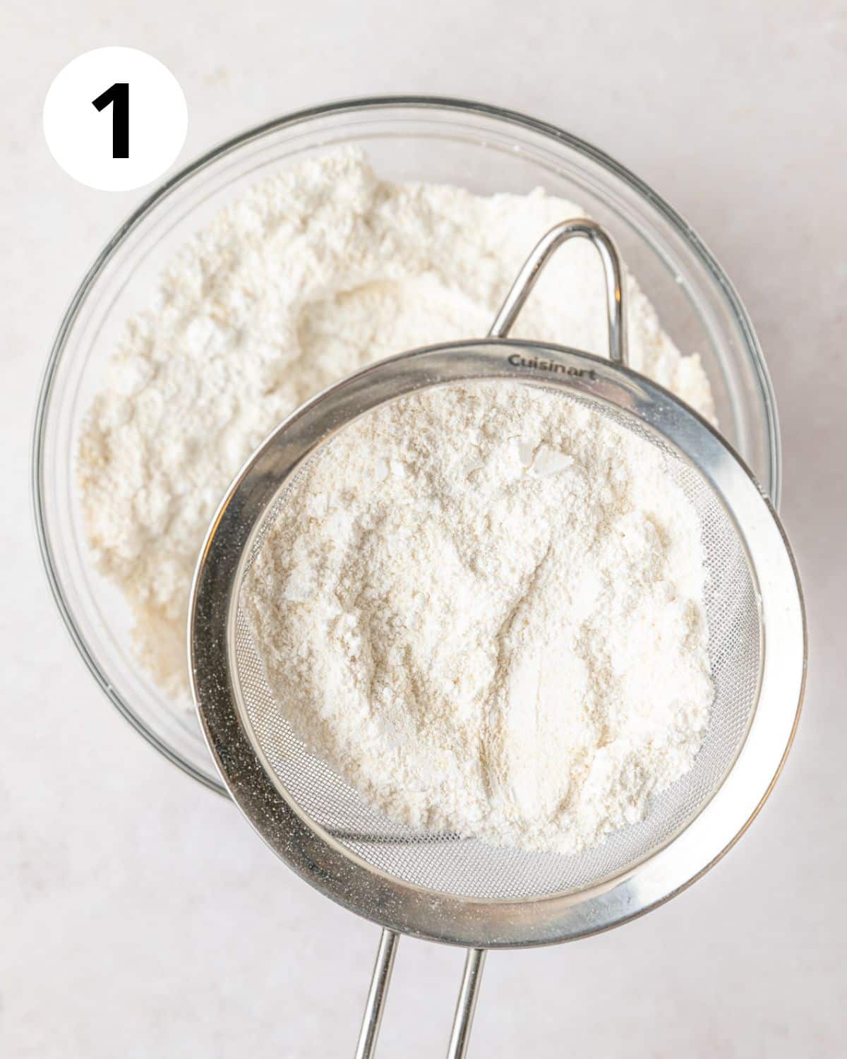 sifting together almond flour and powdered sugar.