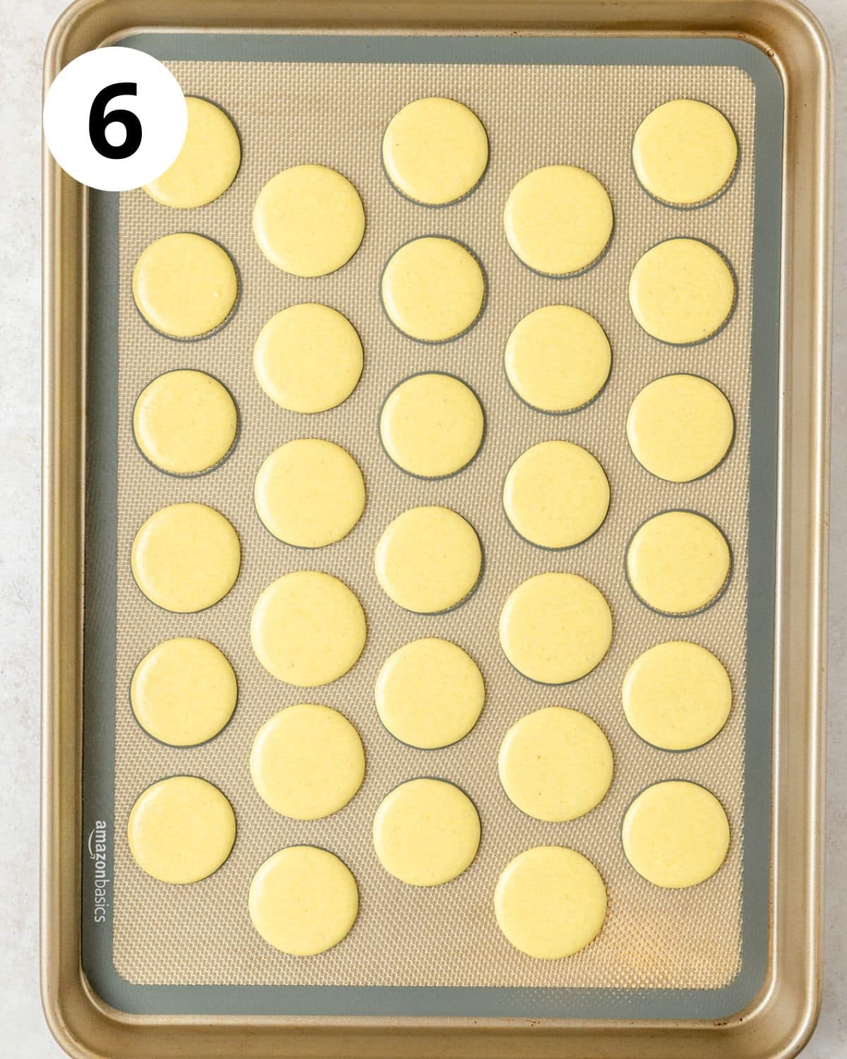 yellow macarons piped before baking.