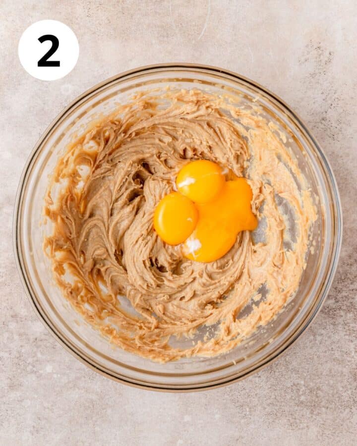 adding egg yolks to cookie dough.