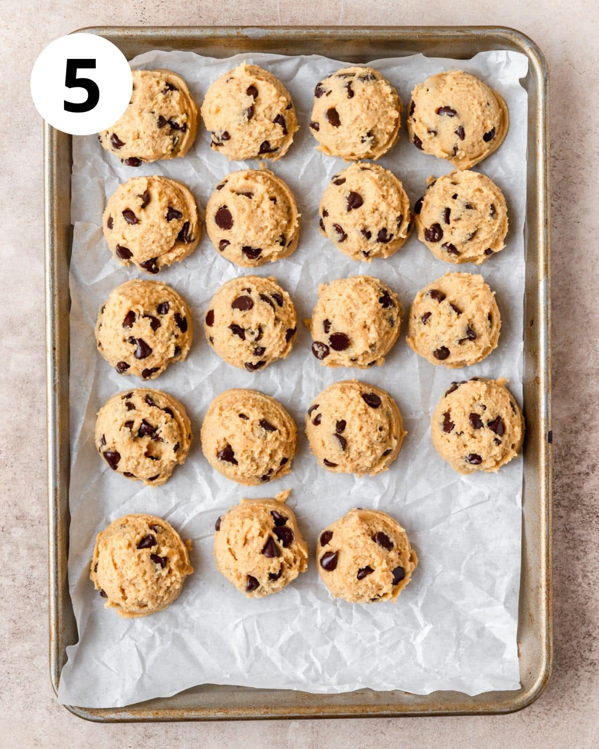 balls of egg yolk chocolate chip cookie dough before baking.