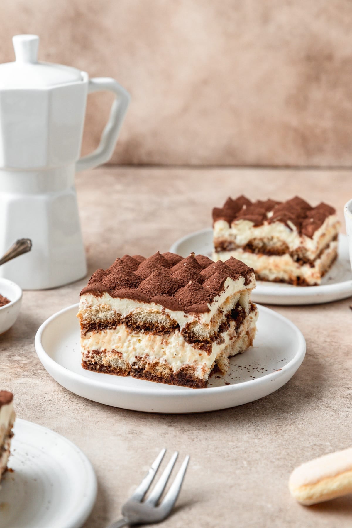 slice of homemade tiramisu topped with cocoa powder.