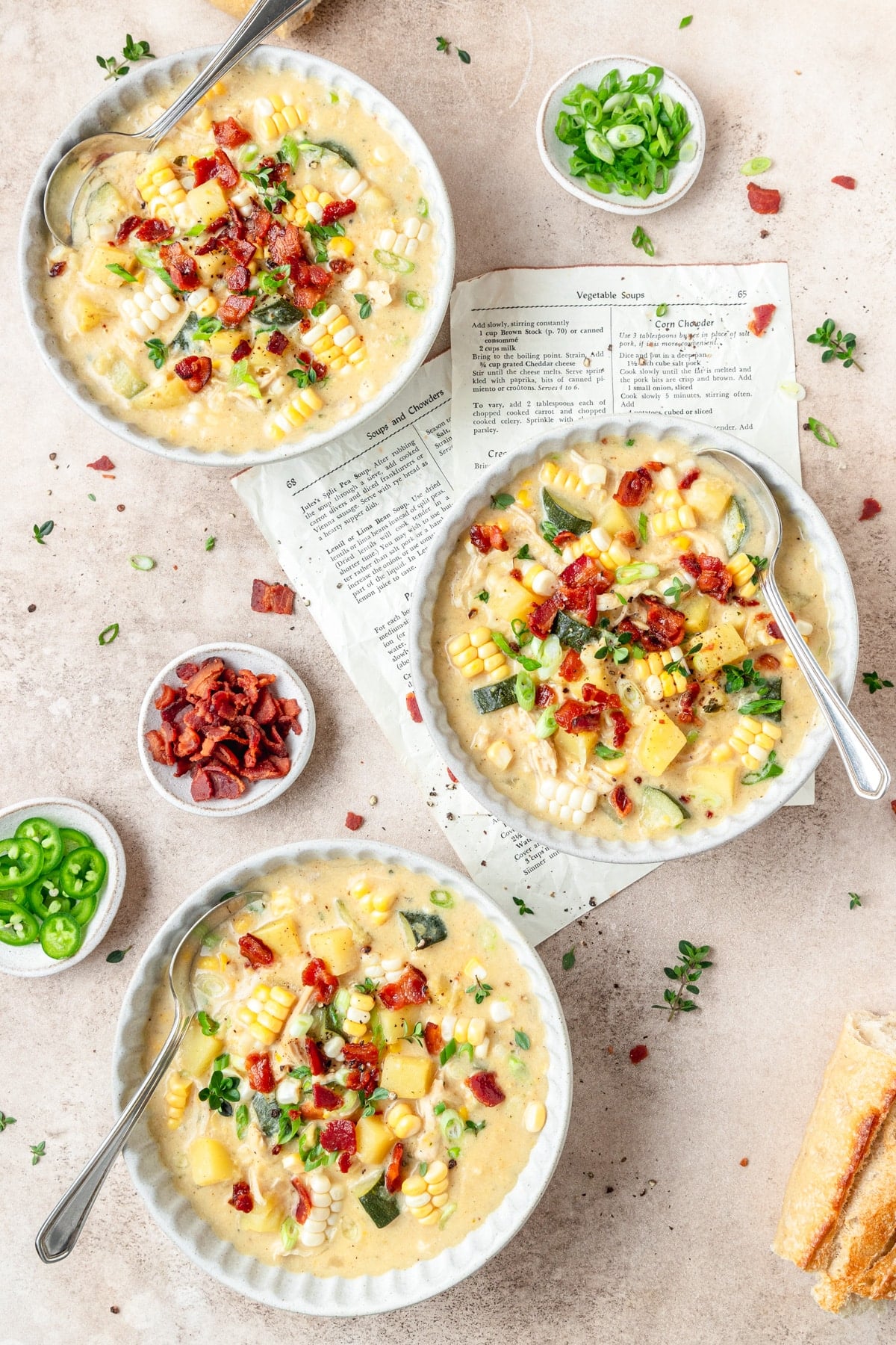 three bowls of creamy chicken corn chowder topped with bacon.