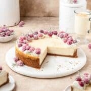 eggnog cheesecake with gingersnap cookie crust and topped with sugared cranberries and rosemary.