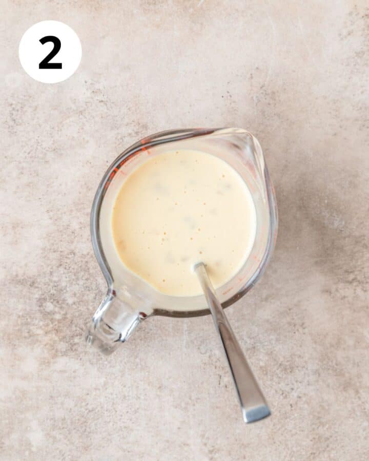 whisking together eggnog and egg.