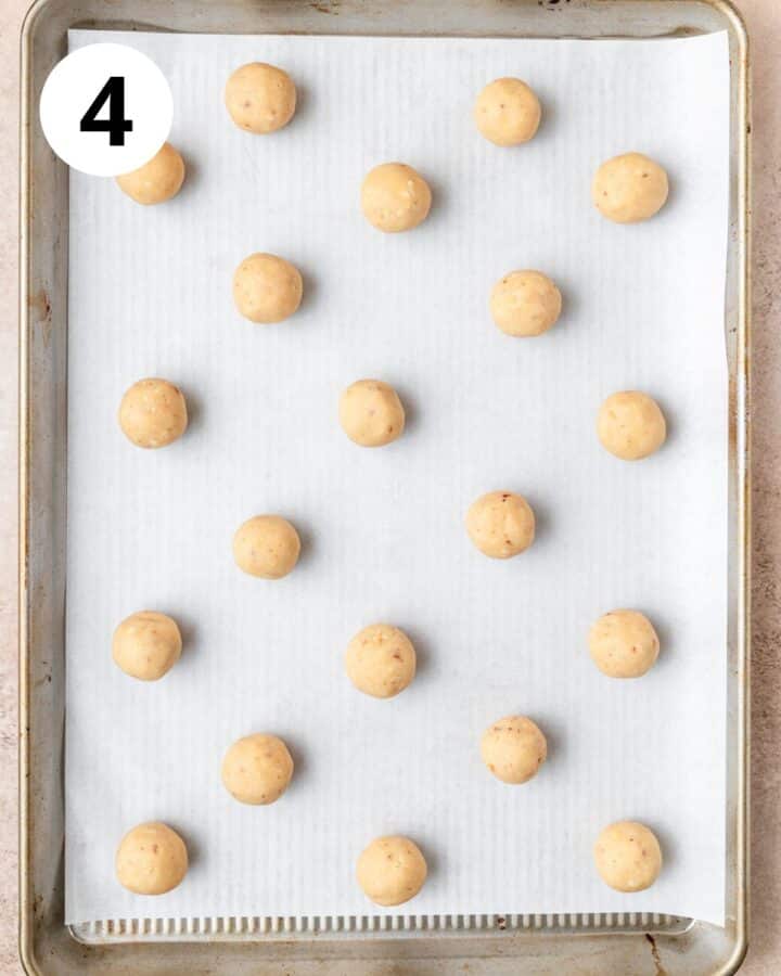 rolled snowball cookies on baking sheet.