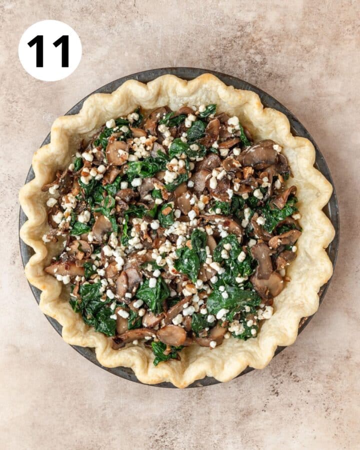 layering mushrooms spinach and goat cheese in pie crust.