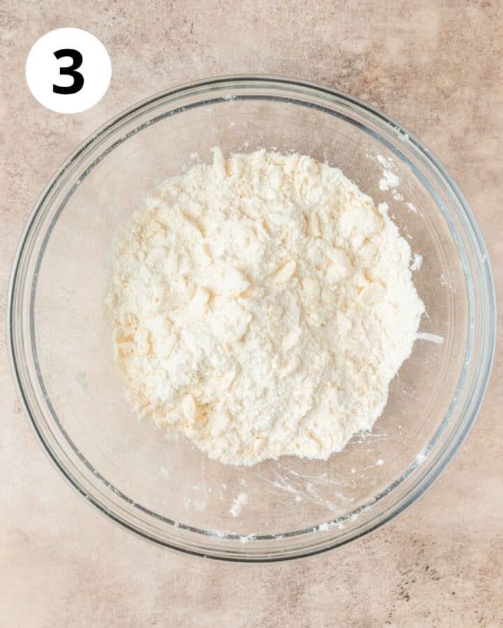 pressing cold butter into flour to form pea sized crumbs.