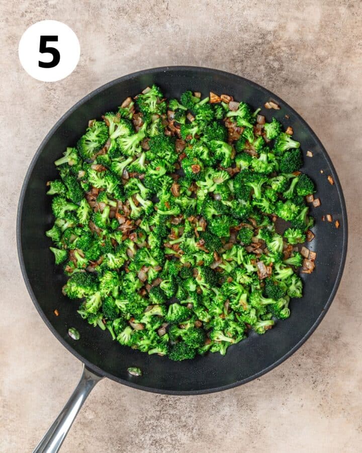 adding broccoli florets to pan to cook down.