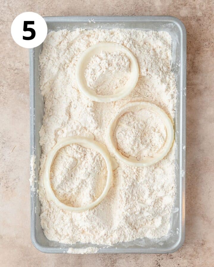 dipping battered onion rings into flour mixture.
