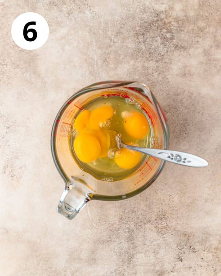 whisking eggs in measuring cup.
