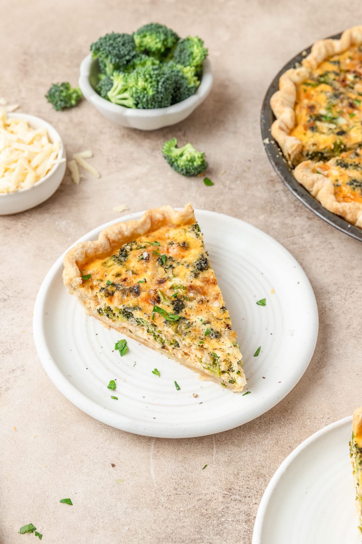 slice of broccoli cheddar quiche on plate.