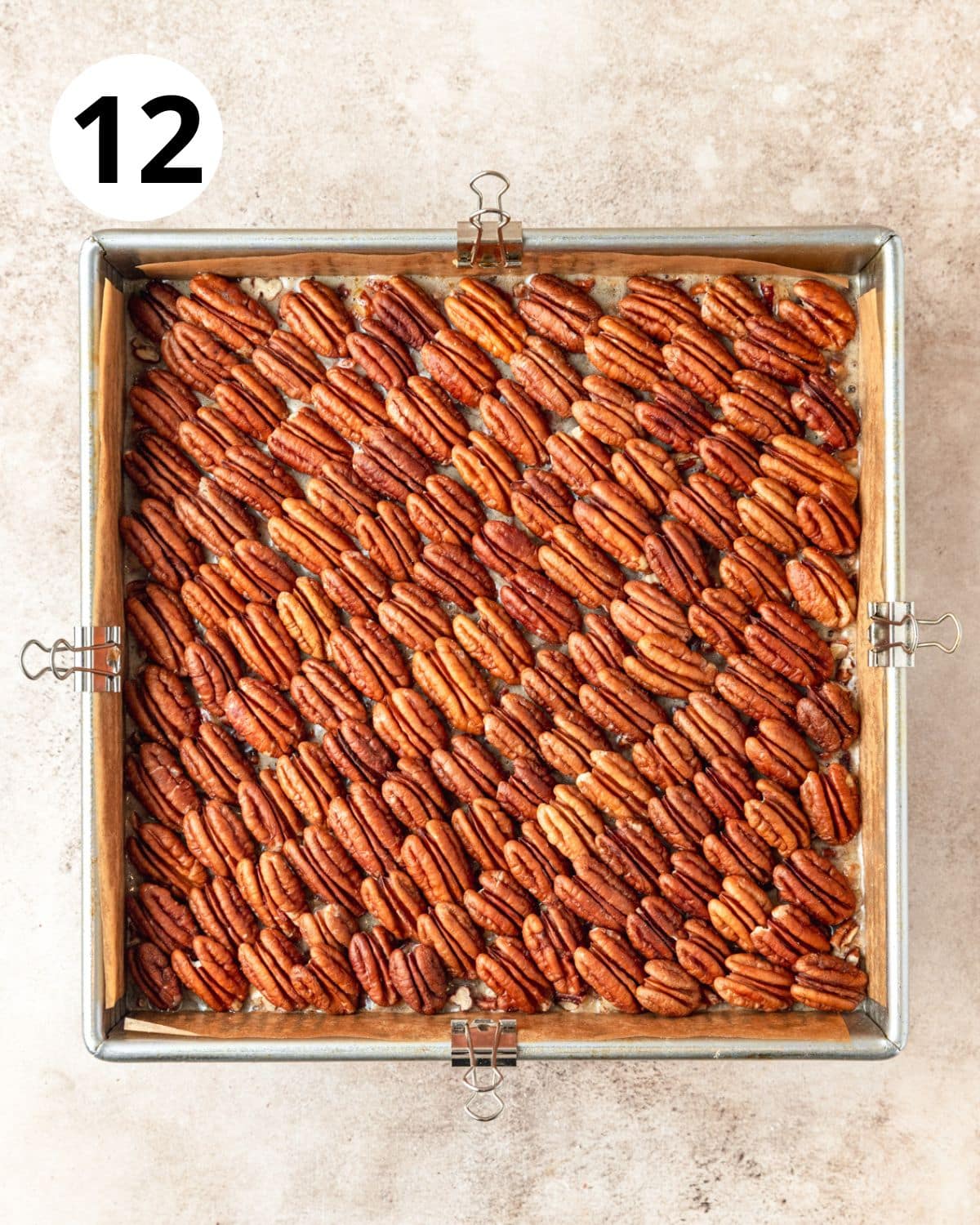 arranging whole pecan halves on top of pie bars.