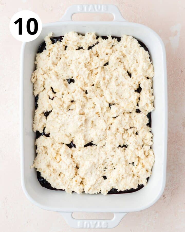 spreading sourdough topping over blueberries.